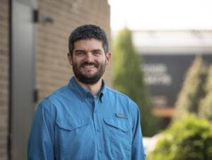 man in blue shirt smiling at camera