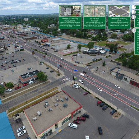 Birds eye view of a busy intersection set amongst stores and their parking lots