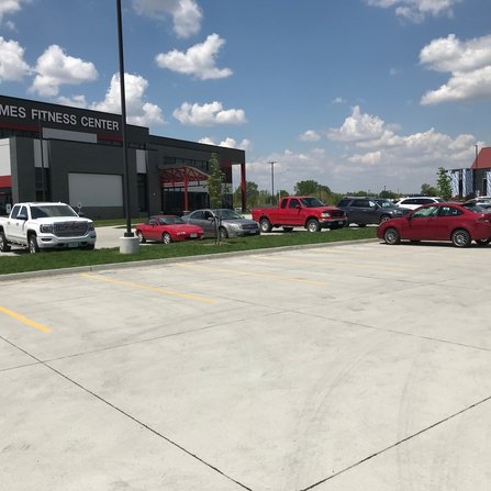 A row of parking spaces with several cars parked in them