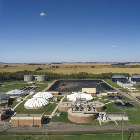 Water treatment tanks and buildings surrounded by fields