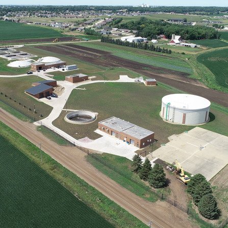 Aerial view of wastewater treatment facility with building and tanks