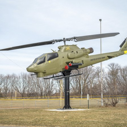 Helicopter monument next to a walking path with trees in the distance
