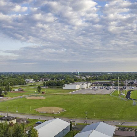 Bird's eye view of track, water tower, baseball field, and distant parking lots