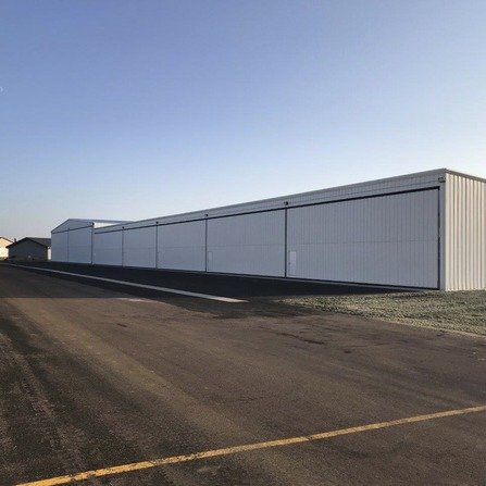 Large aircraft hangar with buildings in the background