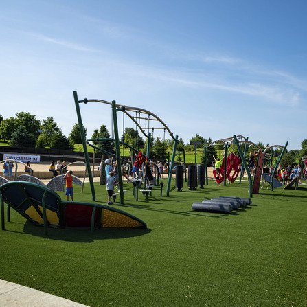 Children playing in a vibrant new park while parents observe