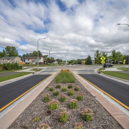 A landscaped median with a roundabout in the distance