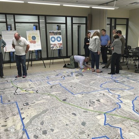 Posters on easels and carpet with a map and people collaboration on pedestrian plans