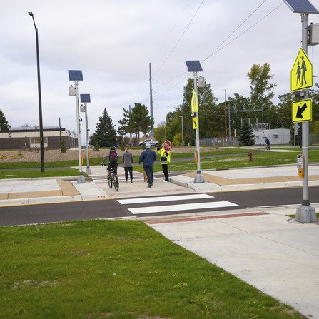 Pedestrians crossing a two-lane road with a middle median