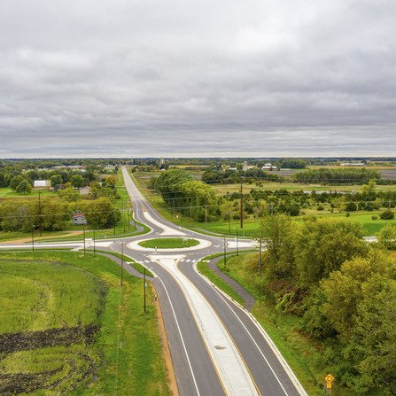 Aerial view of a roundabout surrounded by fields and trees.