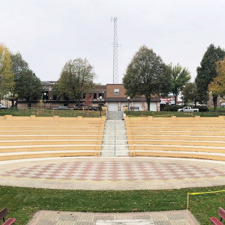 An amphitheater with brick seating and a large central entertainment center