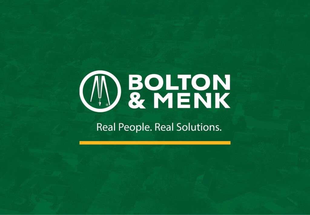 White Bolton & Menk logo and text, Real People. Real Solutions., on a green background with a faint aerial view of a neighborhood. A yellow line sits beneath the tagline.